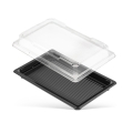 Pojemnik na sushi o wymiarach 215x135x20 mm, składający się z czarnej podstawy z rowkami oraz przezroczystej pokrywy. Produkt leży poziomo, z pokrywą lekko uniesioną. Idealny do przechowywania i transportu sushi.