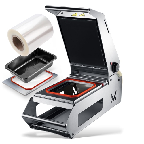 Zgrzewarka pojemników METROOPACK M10 w zestawie z rolką folii i czarnym pojemnikiem. Produkt w otwartej pozycji, z widocznym metalowym korpusem, gumowym uszczelnieniem i regulatorem temperatury. Tło białe, co podkreśla detale urządzenia.