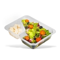 Pojemnik do zgrzewu CORNER FREE METROOMILK o wymiarach 227x178x40 mm, podzielony na dwie komory. Z jednej strony sałatka z pomidorami, oliwkami i sałatą, z drugiej kostki białego sera. Przezroczysty materiał, stabilny kształt.