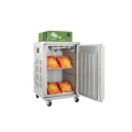 Kontener chłodniczy KOALA GREEN 370 z własnym zasilaniem, w kolorze szarym, z otwartymi drzwiami. Wnętrze z dwoma półkami, na których znajdują się pomarańczowe opakowania. Urządzenie na kółkach, z zieloną jednostką chłodniczą na górze.