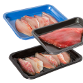 Automatyczna maszyna do zgrzewania Foodpack Speedy V/G Progas MAP. Na zdjęciu widoczne są trzy tace: niebieska z filetem rybnym, czarna z dużym kawałkiem ryby oraz dolna z mniejszymi kawałkami. Tace mają gładką, błyszczącą powierzchnię.